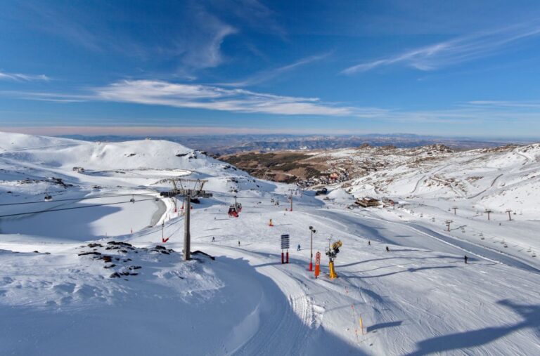 Vista de la estación de esquí de Sierra Nevada con montañas nevadas y pistas de esquí.
